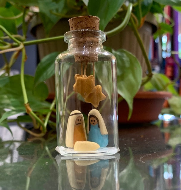 A tiny Nativity scene inside a small corked glass jar
