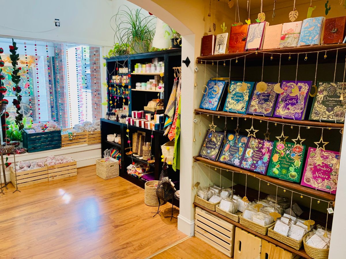 Embossed journals hung on strings beside a cabinet of candles and soaps